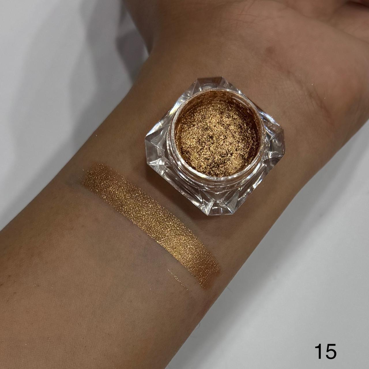 Gold glitter makeup on a wrist with a small container of glitter.