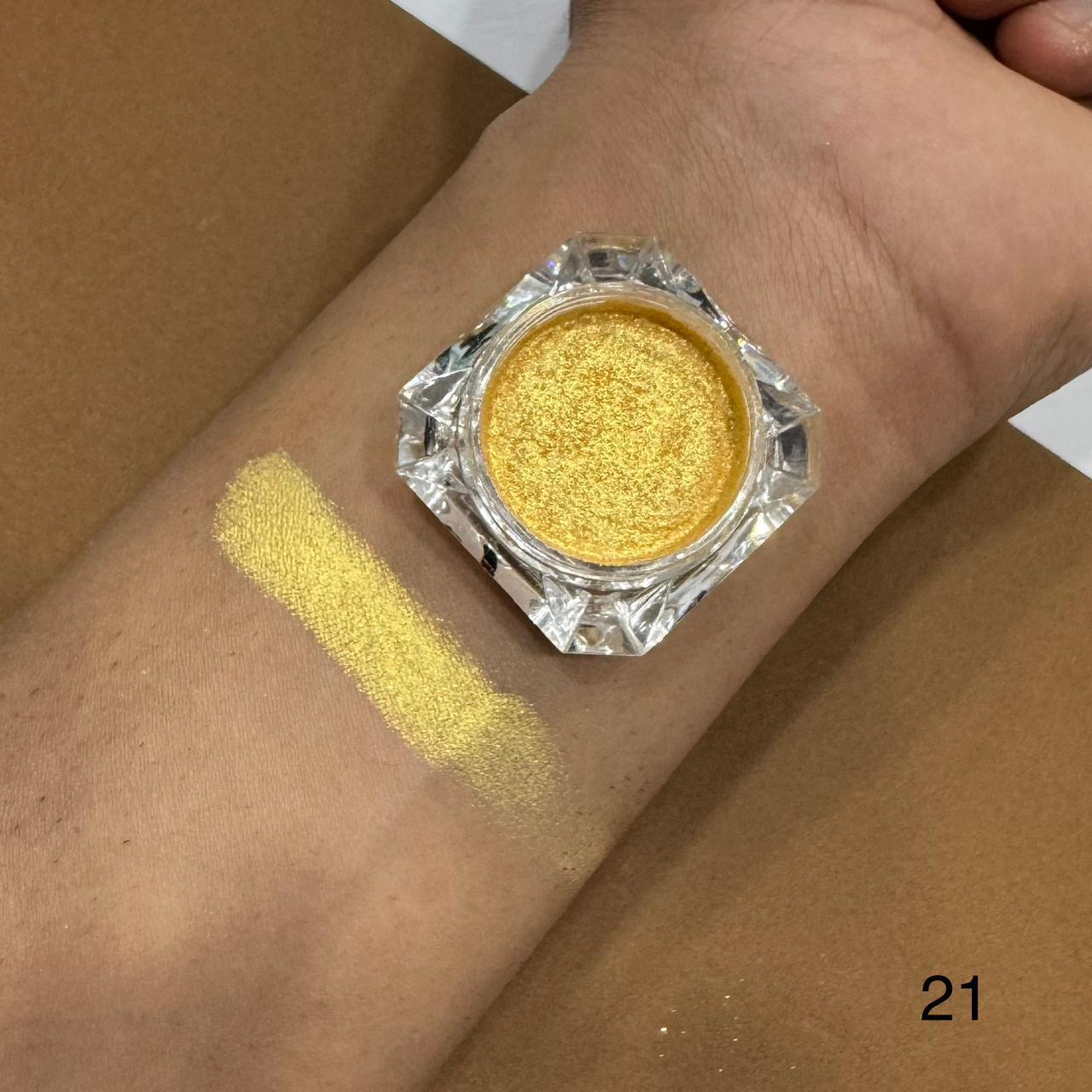 Gold glitter makeup on a wrist with a clear container labeled '21'.