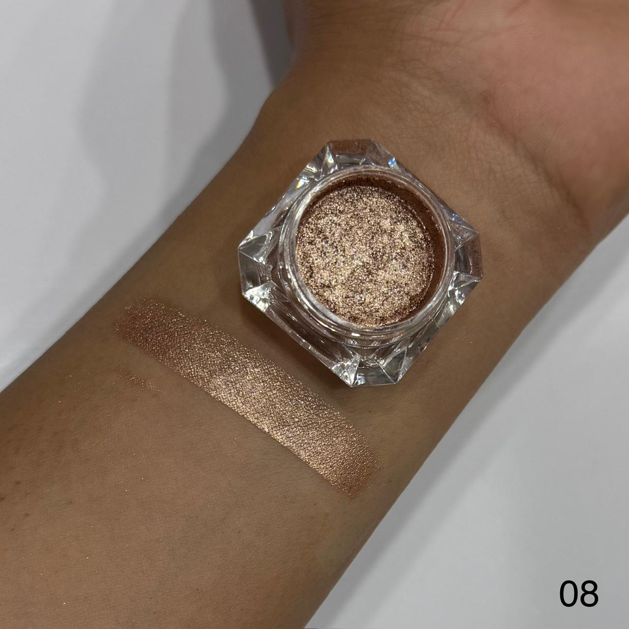 Cosmetic jar of glittery powder on a wrist with swatch, against a neutral background.