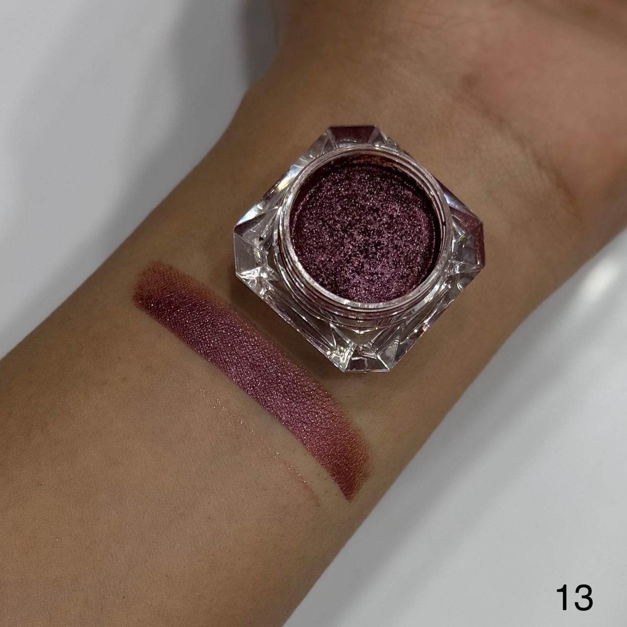 Purple glittery eye shadow on a wrist with a swatch.