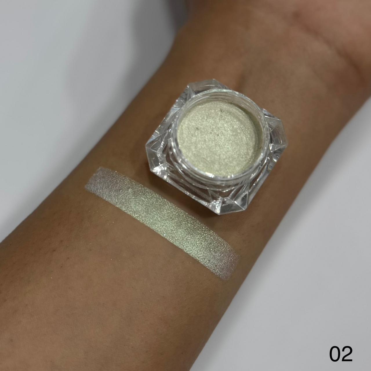 Green glittery makeup powder in a jar on a person's wrist with a swatch.