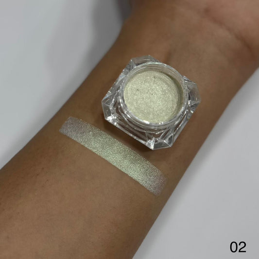 Green glittery makeup powder in a jar on a person's wrist with a swatch.