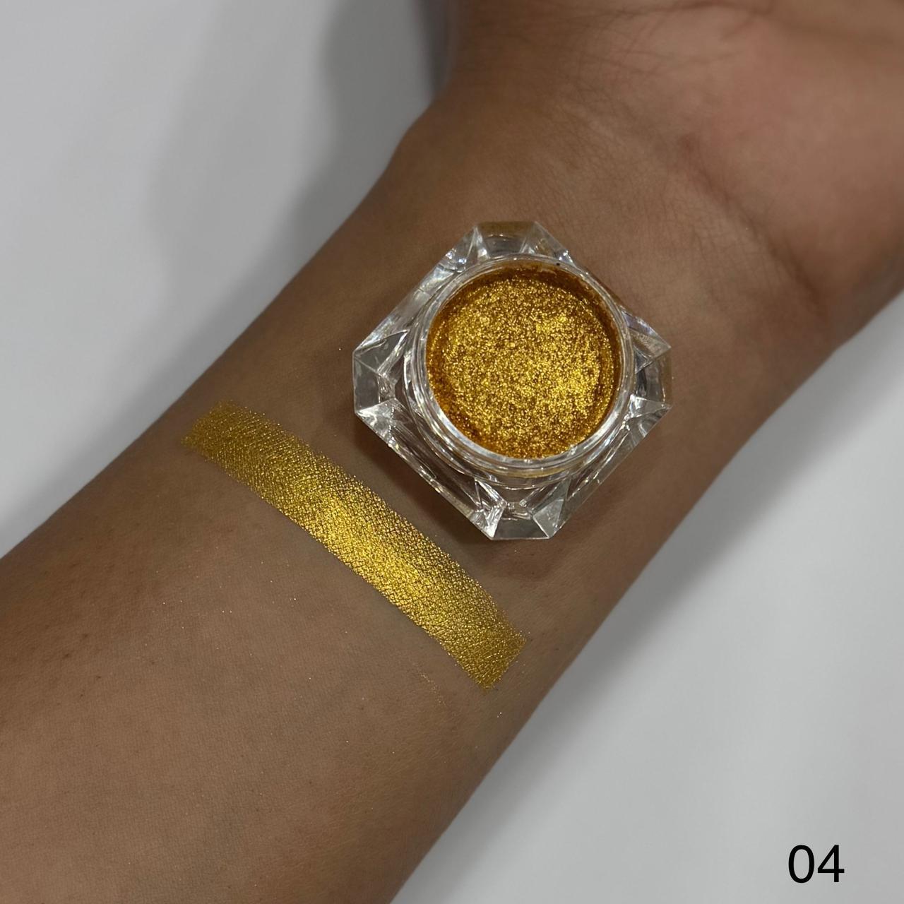 Gold glitter makeup on a wrist with a small container of glitter.
