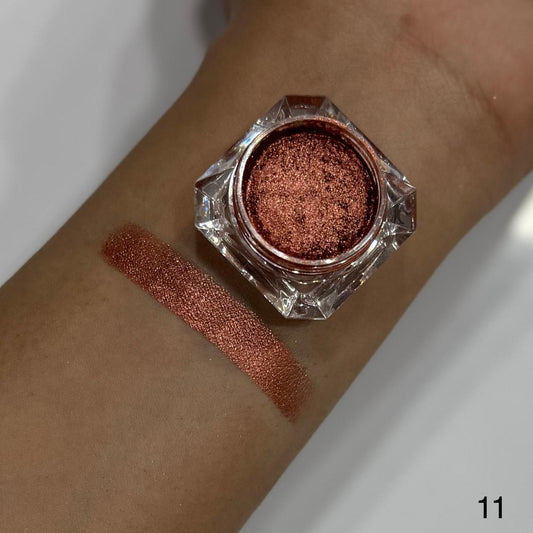 Bronze glittery eye shadow in a jar on a wrist with swatch