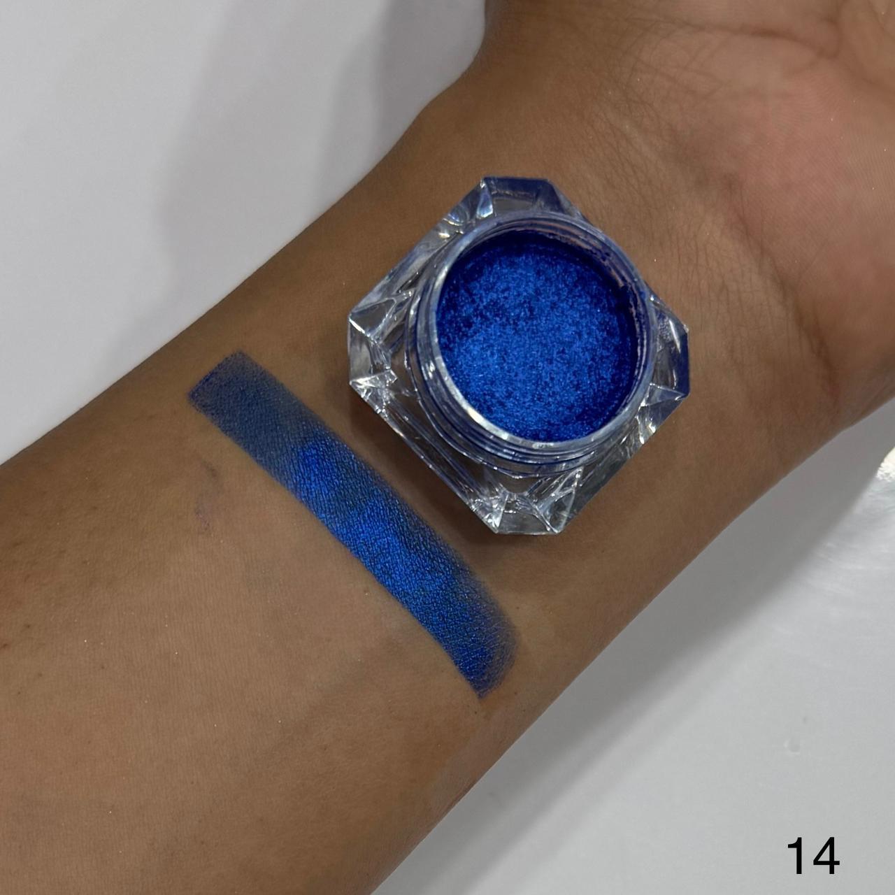 Blue glitter makeup on a wrist with a jar of blue glitter next to it.