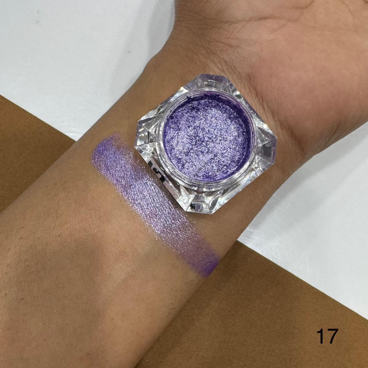Purple glitter makeup on a wrist with a jar of glitter next to it.