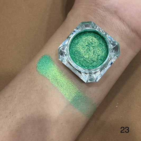 Green glitter makeup on a wrist with a jar of green glitter above it.