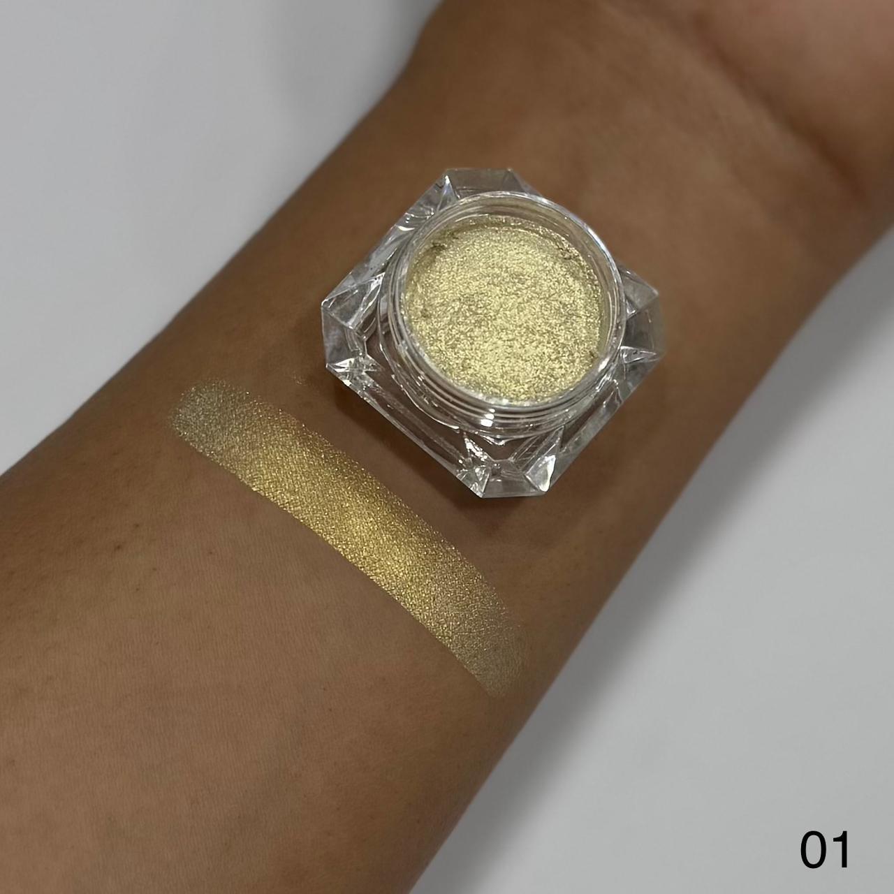 Gold glitter makeup on a wrist with a jar of glitter above it.